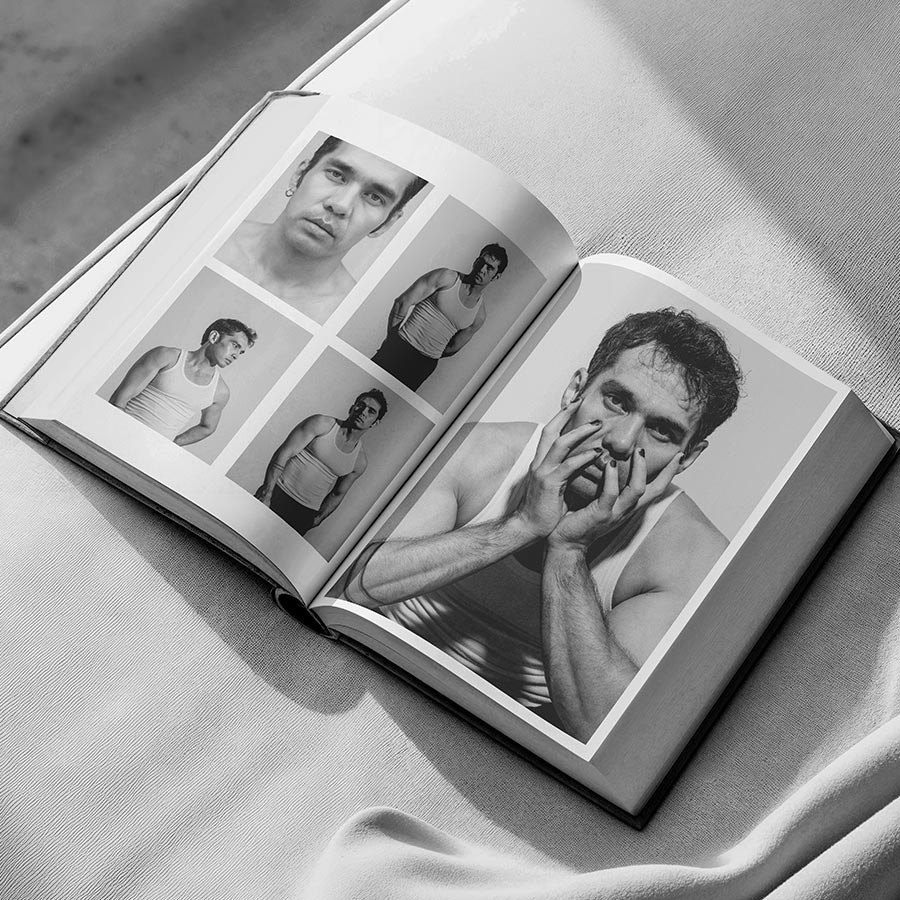 This image showcase a modeling portfolio opened up on top of a bed on a beach.